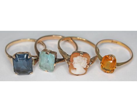 A group of four rings comprising a hallmarked 9ct gold ring set with blue paste, three other rings marked '9ct', sizes K-O, g