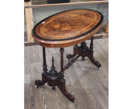 A Victorian walnut cross banded and inlaid oval occasional table with quarter veneered figured top raised on four turned pill