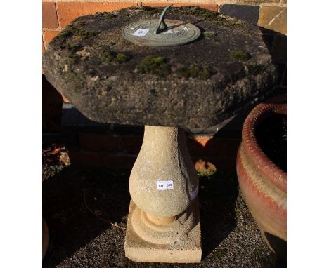 A cast concrete sundial on baluster column pedestal.