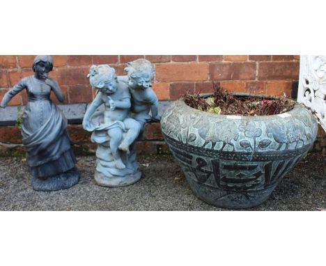 A Verdigris patinated planter with two small garden statutes.