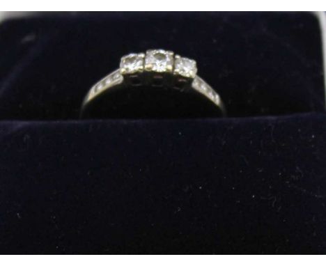 A 9ct white gold diamond ring, set three stones, with three smaller stones inset to the shoulders, gross weight: 1.9g, ring s
