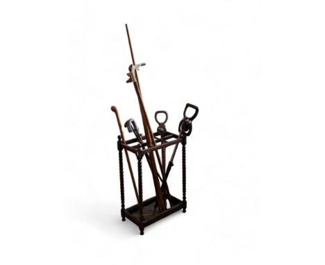 An oak bobbin twist stick stand with a selection on canes/shooting sticks etc... 46cm by 27cm by 71cm