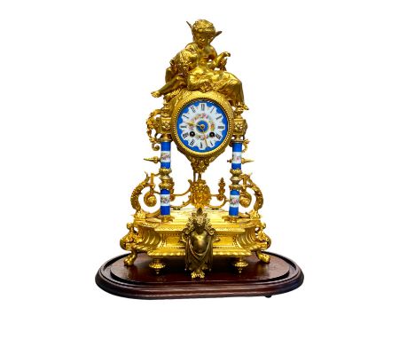 A 19th Century French Ormolu and Porcelain pillar clock, surmounted by Cupid and Venus, under a replacement glass dome, runni