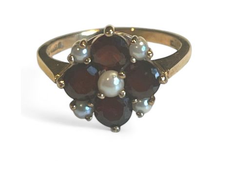 A 9ct gold garnet and seed pearl flower ring. Size K. Gross weight approximately 2.61 grams.