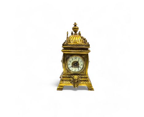 A French brass Mantel clock, elaborately decorated with a dome and finial surmount, the dial over a foliate cast frieze cente