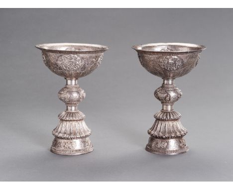 A LARGE PAIR OF SILVER BUTTER LAMPSTibetan-Chinese, 19th century. The fine pair with a deep bowl incised and embossed with fo