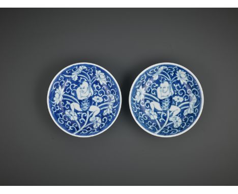 A NEAR-PAIR OF BLUE AND WHITE 'LOTUS BOY' DISHES, KANGXI PERIODChina, 1662-1722. Each with shallow sides rising from a flat f