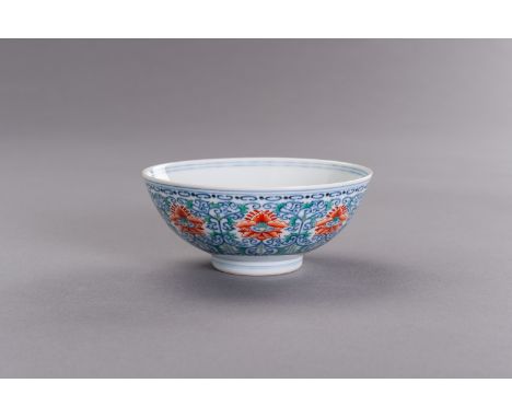 A DOUCAI ENAMELED PORCELAIN 'FLORAL' BOWLChina, 20th century. Painted in underglaze blue as well as iron-red and green enamel