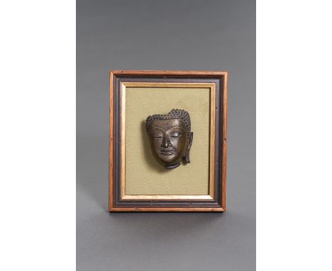 A BRONZE BUDDHA HEAD, SUKHOTHAIThailand, Sukhothai period (1238-1438), 15th century. The fragment of a bronze buddha head wit