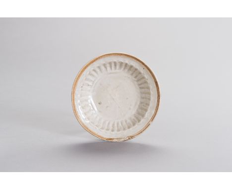 A MOLDED QINGBAI DISHChina, Yuan Dynasty (13th - 14th century). The rounded sides of the small dish with molded radiating gro