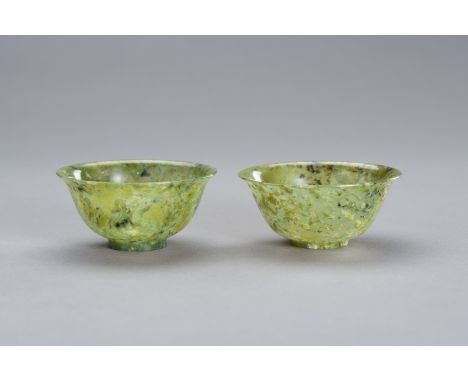 A MOTTLED PAIR OF SPINACH GREEN JADE BOWLSChina, late Qing to Republic period (1880-1950). The thin rounded sides rising from