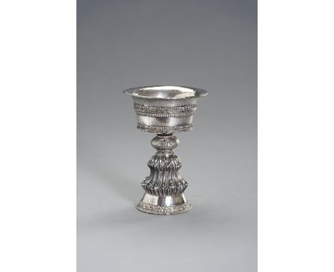 A TIBEATAN-CHINESE SILVER BUTTER LAMPTibetan-Chinese, 19th century. The fine deep stem bowl with applied beaded bands and rim