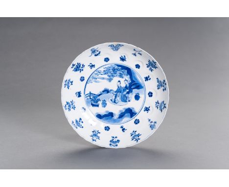 A BLUE AND WHITE PORCELAIN 'GARDEN SCENE' BARBED-RIM DISH, KANGXIChina, Kangxi period (1662-1722). The lobed sides rising fro