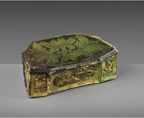 A GREEN-GLAZED CIZHOU 'PEONY' PILLOW, SONG TO JIN DYNASTYChina, 960-1234. Covered with a bright green glaze over a white-slip