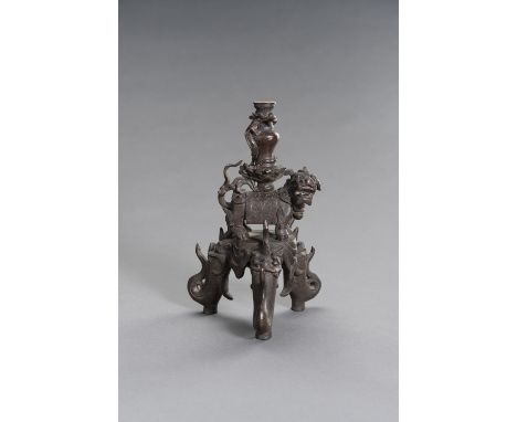 A FIGURAL CHINESE BRONZE LAMP STANDChina, 19th century. The figural bronze lamp stand with a Buddhist lion carrying a vase on