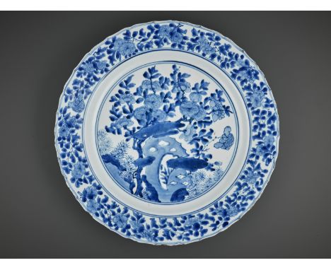 A LARGE BLUE AND WHITE 'PRUNUS AND LINGBI' LOBED DISH, KANGXI MARK AND PERIODChina, 1662-1722. The shallow sides rising from 