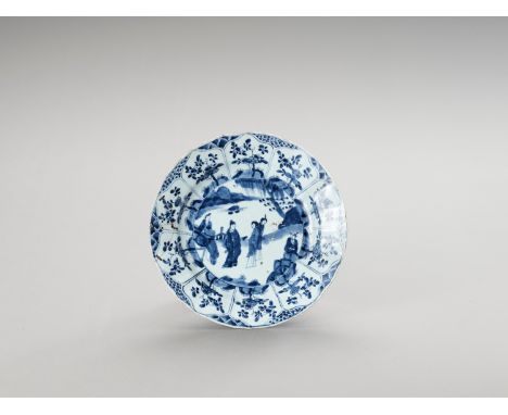A LOBED BLUE AND WHITE PORCELAIN DISHChina, Kangxi period (1662-1722). Painted in underglaze blue, the show side with an enci
