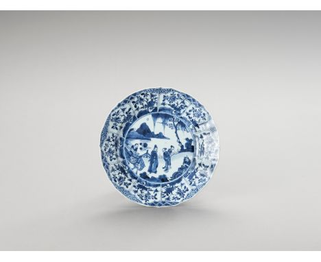 A LOBED BLUE AND WHITE PORCELAIN DISHChina, Kangxi period (1662-1722). Painted in underglaze blue, the show side with an enci
