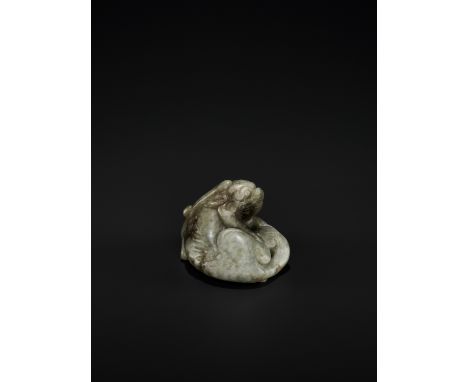 A GRAYISH-GREEN JADE 'BIXIE' CARVING, YUAN TO MING DYNASTYChina, 1279-1644. Carved in a recumbent position with one paw scrat