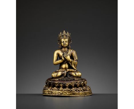 A GILT BRONZE FIGURE OF A CROWNED BUDDHA, DATED 1709Tibet. Seated in dhyanasana on a separately crafted unsealed copper repou