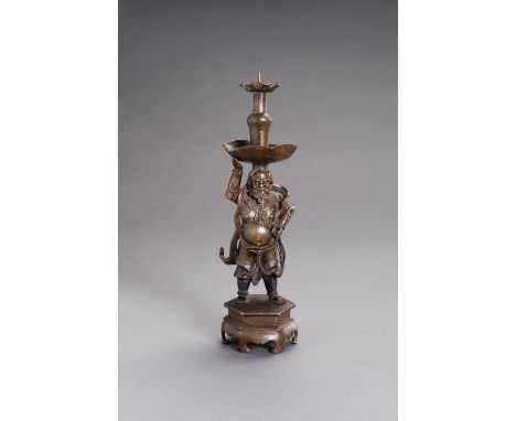 A BRONZE 'FOREIGNER' CANDLESTICKChina, late Ming Dynasty (1368-1644). The bearded foreigner cast on a hexagonal base with his