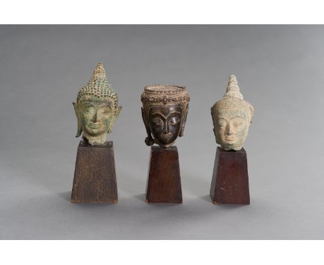 A LOT WITH THREE BRONZE BUDDHA HEADSThailand, 17th - 19th century. The group of three bonze buddha heads with delicate cast a