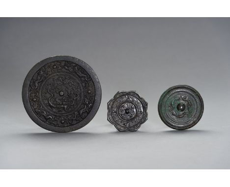 THREE TANG STYLE BRONZE MIRRORSChina, Qing Dynasty (1644-1912) or earlier. Consisting of one octofoil mirror, the pierced kno