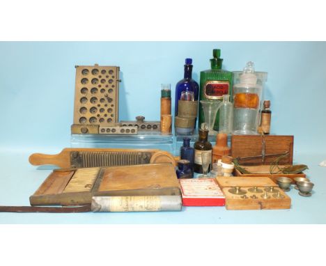 A collection of pill-making equipment, a green "Acid Carbol:l:" bottle, other bottles, scales, weights, etc. 