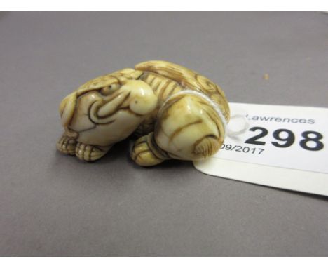 Japanese Meiji period carved ivory netsuke in the form of a reclining shishi, 4cms wide approximately