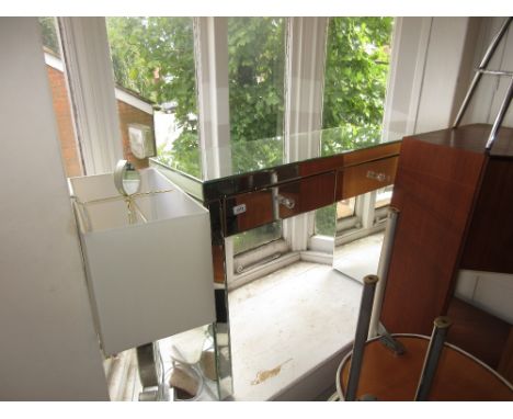 Modern mirrored two drawer dressing table together with a similar table lamp