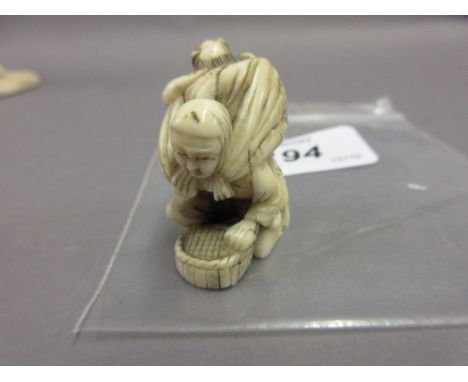 Japanese Meiji period ivory netsuke, carved as a kneeling figure with child