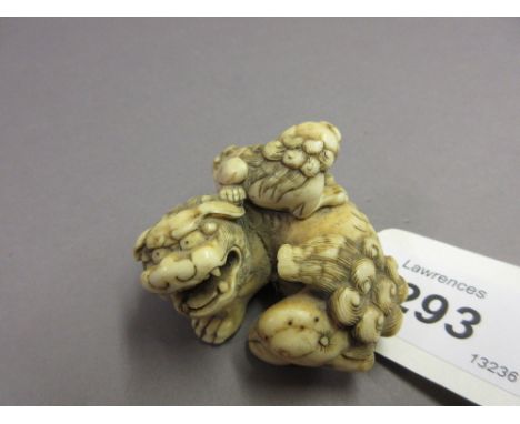 Good 19th Century Japanese carved ivory Meiji period netsuke in the form of a recumbent shishi with young, 5cms wide approxim