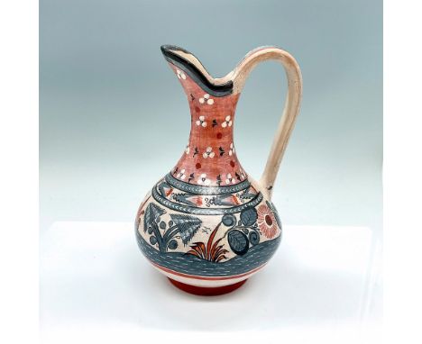 Hand painted pitcher depicting a deer resting beside a river. Blue, white, and red coloration. Artist name and country handwr