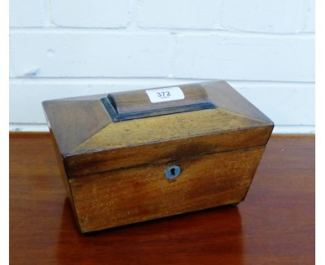 A 19th century mahogany tea caddy with twin division interior on four bun feet, 23cm long