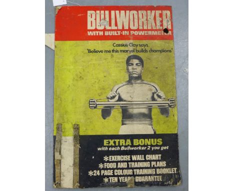 A vintage Bullworker advertising board - Cassius Clay says 'believe me, this marvel builds champions', 60 x 93cm (distressed)