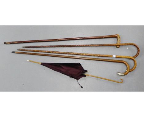 A collection of three silver mounted walking sticks, a walking cane and a vintage parasol, (5) 