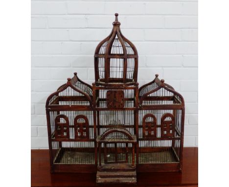 A vintage bird cage with minaret top to centre flanked by arched tops and small clock face , 
