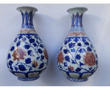 A pair of Chinese Imari porcelain vases, the swelling bodies with slender necks to flared rims, painted upright lappets and C