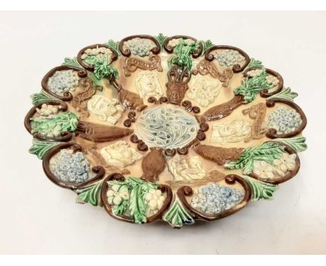 Castle Hedingham Edward Bingham pottery dish decorated with masks and flowers on brown and green ground, 25cm diameterConditi