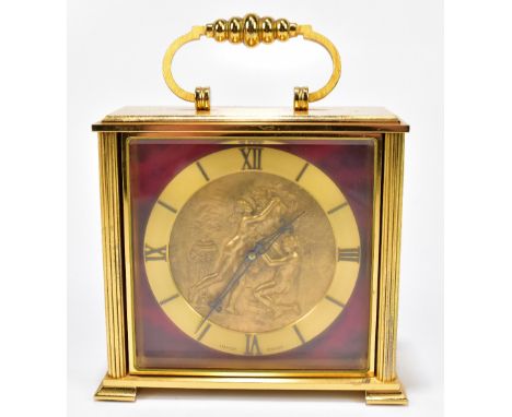 IMHOF; a Swiss gilt metal mantel clock with rotating dial, raised on bracket feet, height including swing handle 14cm.Additio
