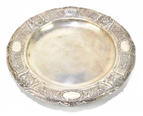 A German 800 grade silver plate of circular form, the decorated rim set with four oval panels, three being vacant and one wit