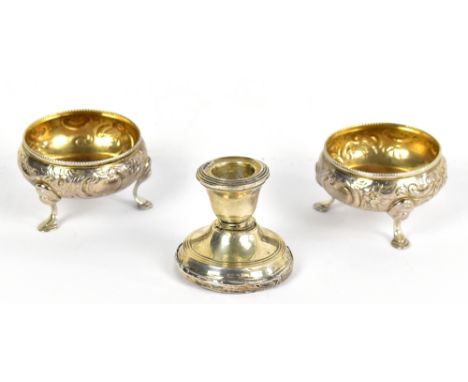 A pair of Victorian open salts with gilded interiors, with repoussé floral decoration raised on three pad feet, London 1891, 