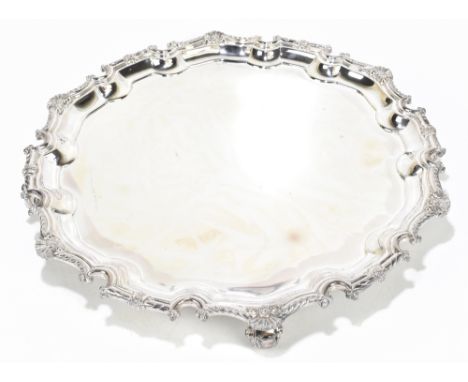 C.J VANDER LTD; an Elizabeth II hallmarked silver salver with cast scalloped edge, raised on three scrolling feet, London 196
