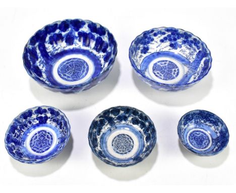 Five Japanese blue and white ceramic footed bowls, each decorated with various landscape scenes, diameter of largest example 
