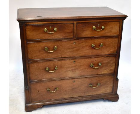 A late George III mahogany chest of two short and three long graduated drawers raised by quarter fluted pilasters on reduced 