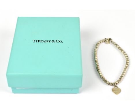 ATTRIBUTED TO TIFFANY &amp; CO; a silver bead bracelet with heart shaped charm, length 18.5cm.Additional InformationThe ename