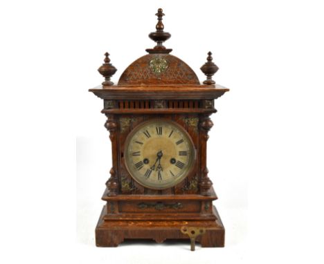 JUNGHANS; an early 20th century oak cased mantel clock, with turned wooden finials and applied gilt metal mount surrounding t