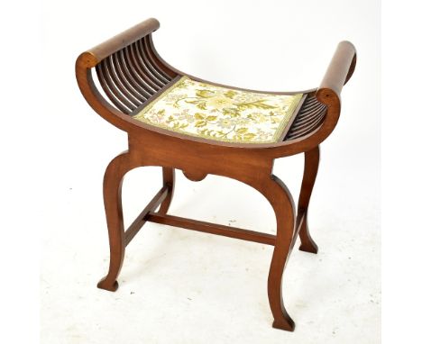An Edwardian mahogany piano stool with dished top raised on swept supports, width 58cm, height 63cm.