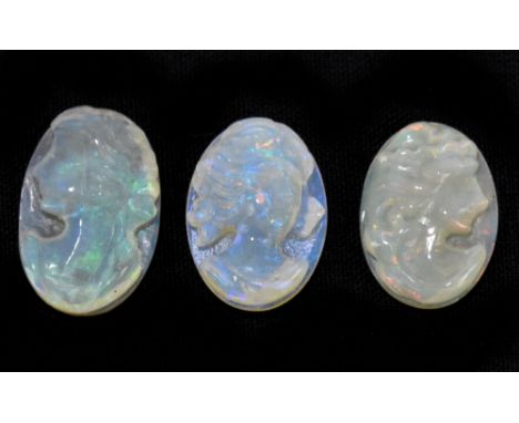 OPAL; three 14 x 10mm opal cabochons each carved with the portrait of a young woman.