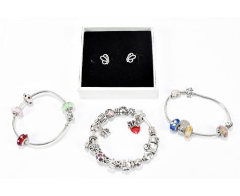 PANDORA; three charm bracelets set between them with a large number of charms and a pair of ear studs.Additional InformationT